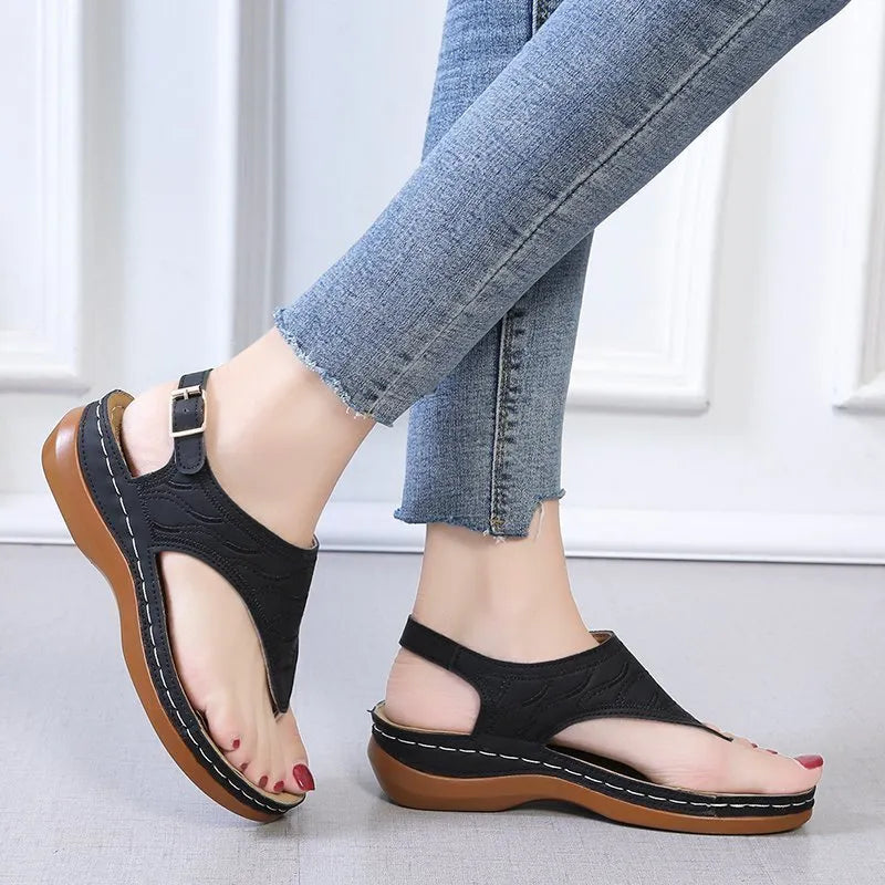 Women's casual wedge heel flip flop sandals with an adjustable buckle strap on the back, shown in a solid colour.