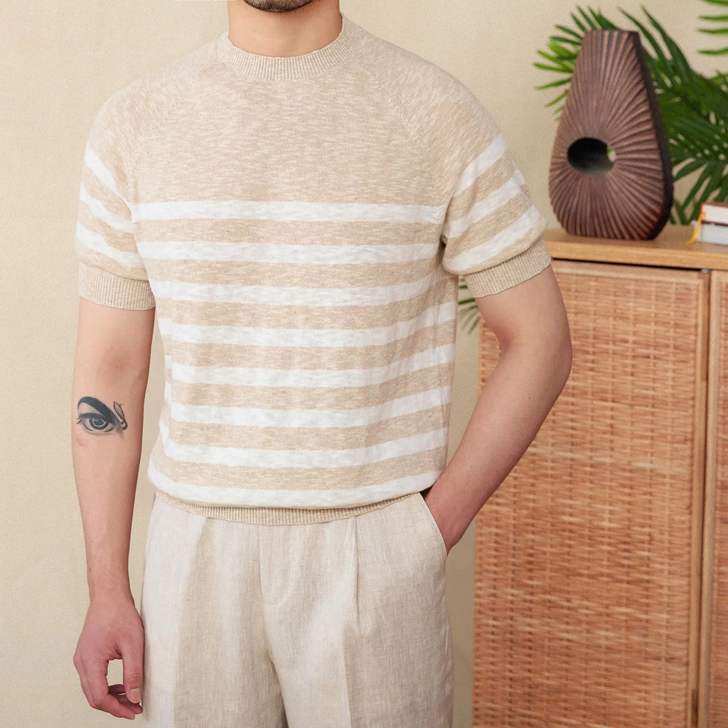 Man wearing a navy blue and white striped short sleeve linen-cotton blend t-shirt with a round neck.