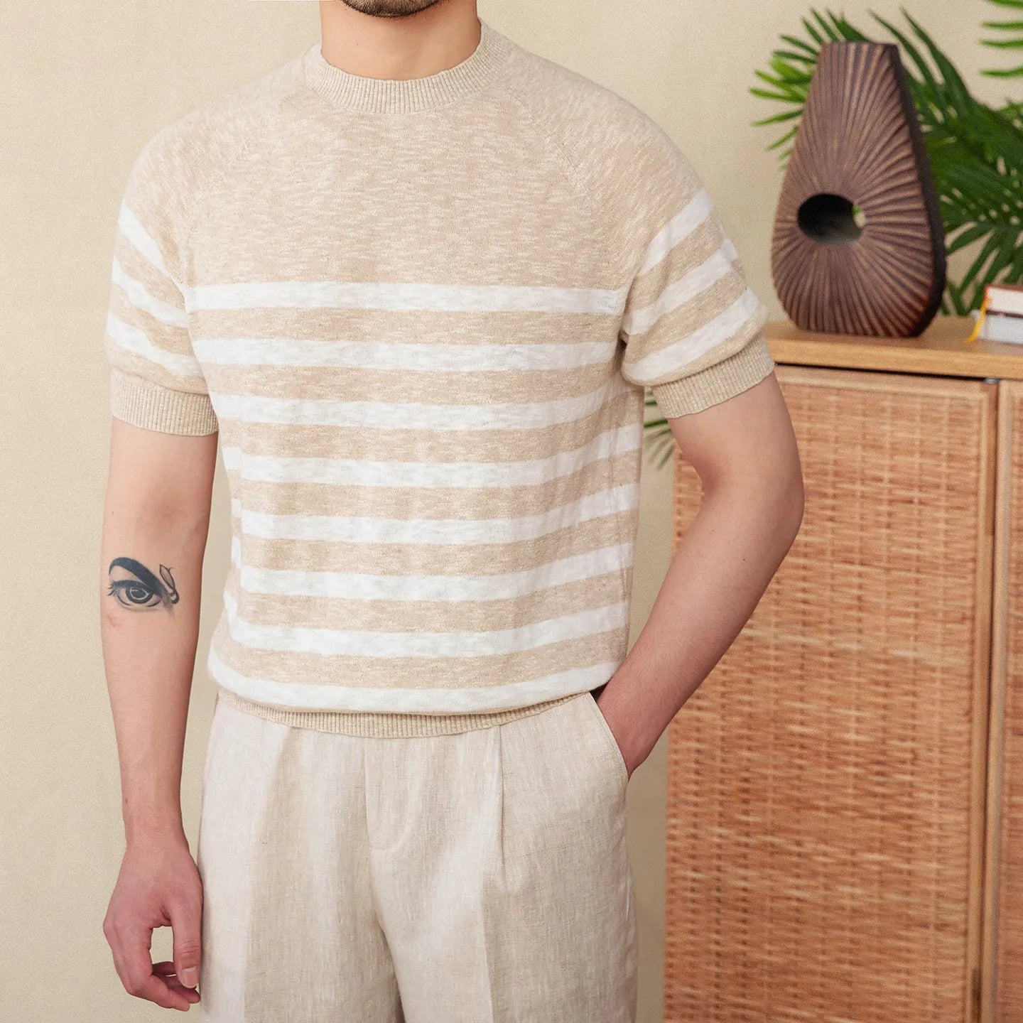 Man wearing a navy blue and white striped short sleeve linen-cotton blend t-shirt with a round neck.