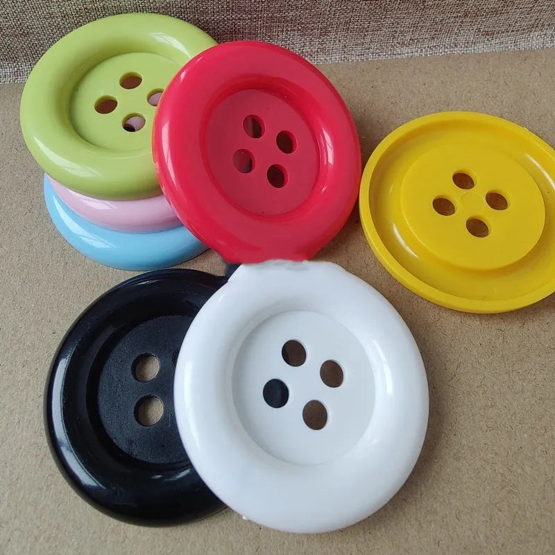 Oversized round plastic buttons with four holes in various colours and sizes from 38mm to 70mm diameter