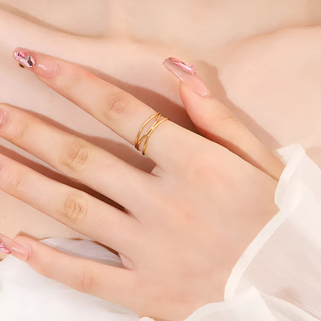 Gold-coloured geometric line ring with a three-layer coil design on a titanium steel band.