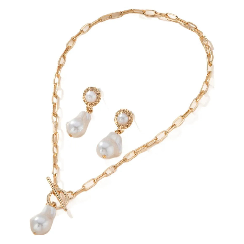 Gold-coloured iron necklace and earrings set with baroque pearl decorative elements on dark background