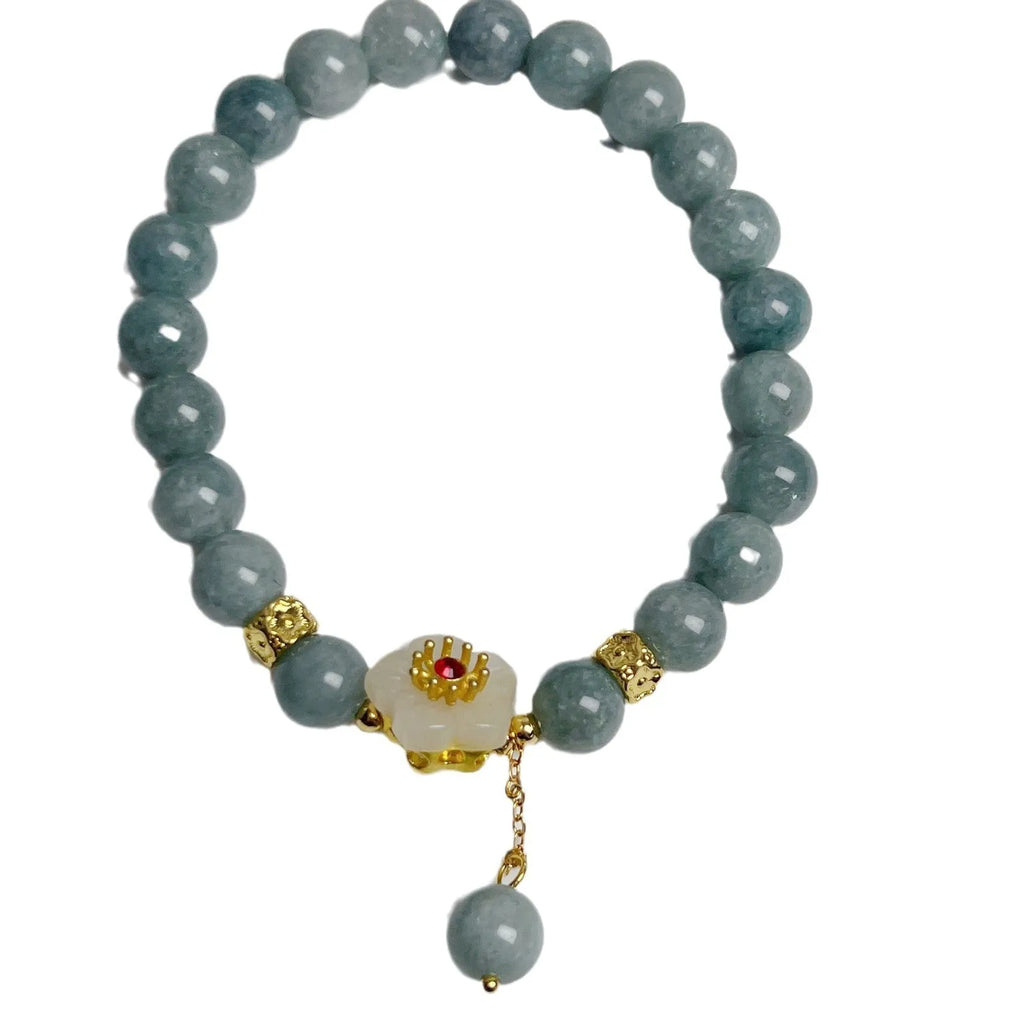 Handmade green jade bracelet with adjustable cotton cord fastening on a wrist.