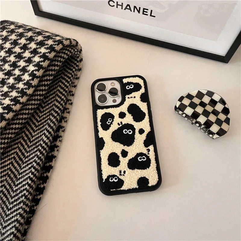 Black plush fairy-themed funny back cover case for iPhone on a table