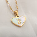 Gold-plated heart-shaped white shell initial necklace on a model, showing the adjustable clavicle chain.