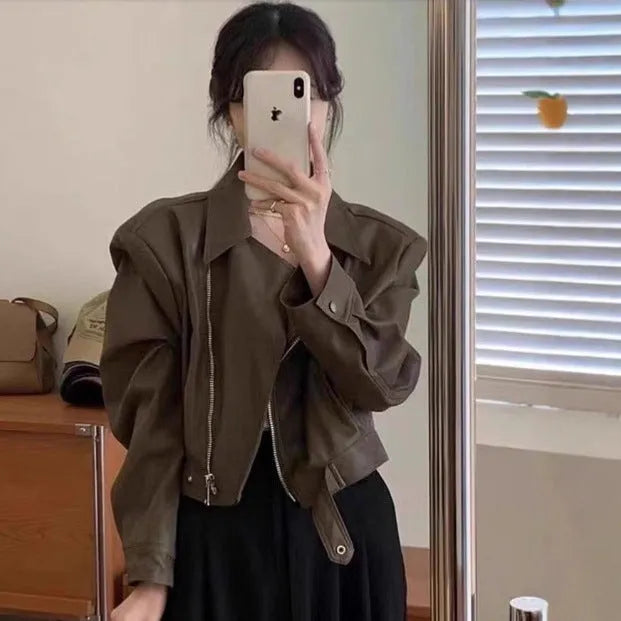 Brown women's retro slim-fit imitation leather jacket with a pocket on a hanger.