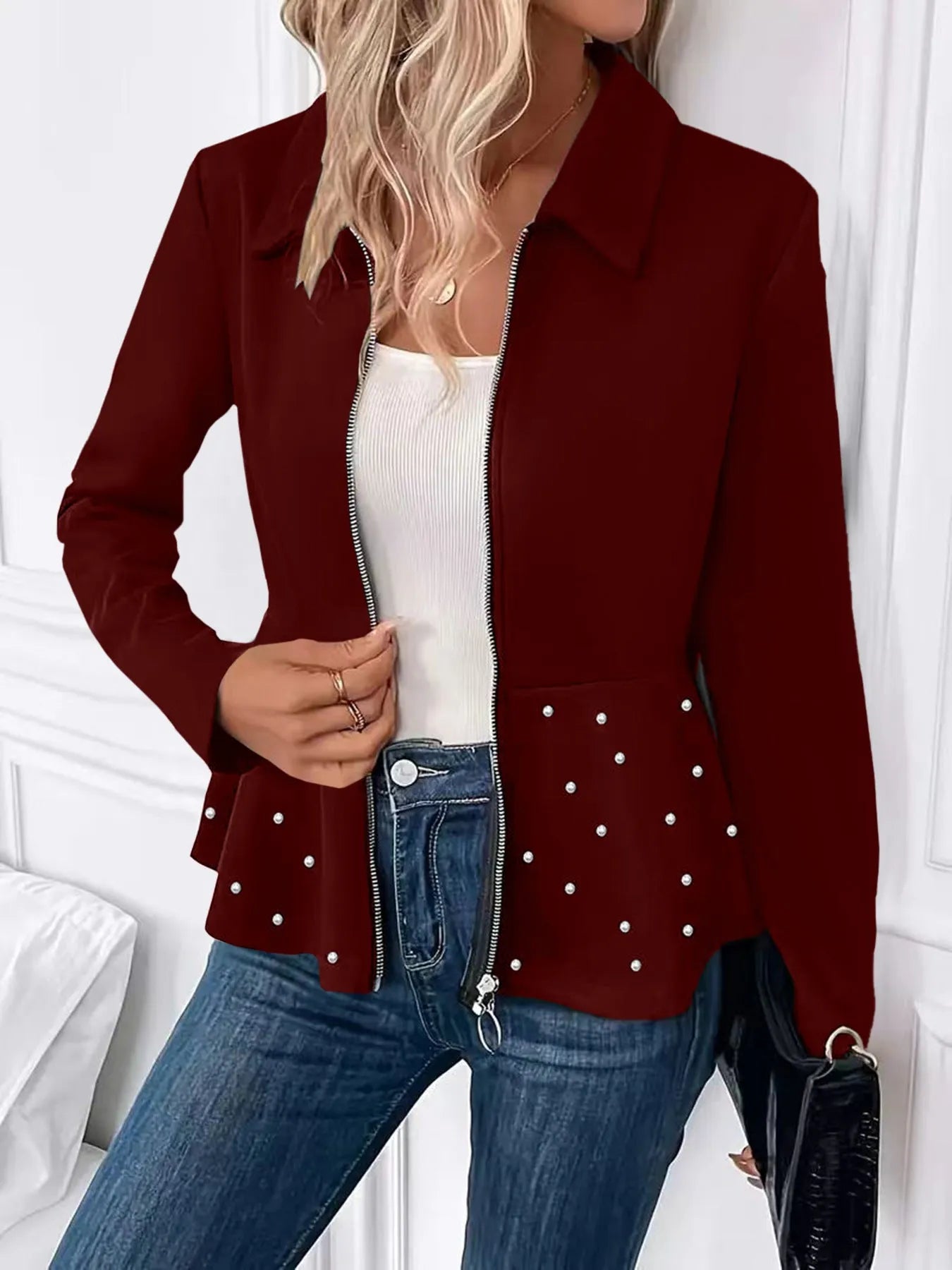 Women's loose-fit black coat with heavy-duty beaded zipper and ruffled hem, long sleeves.