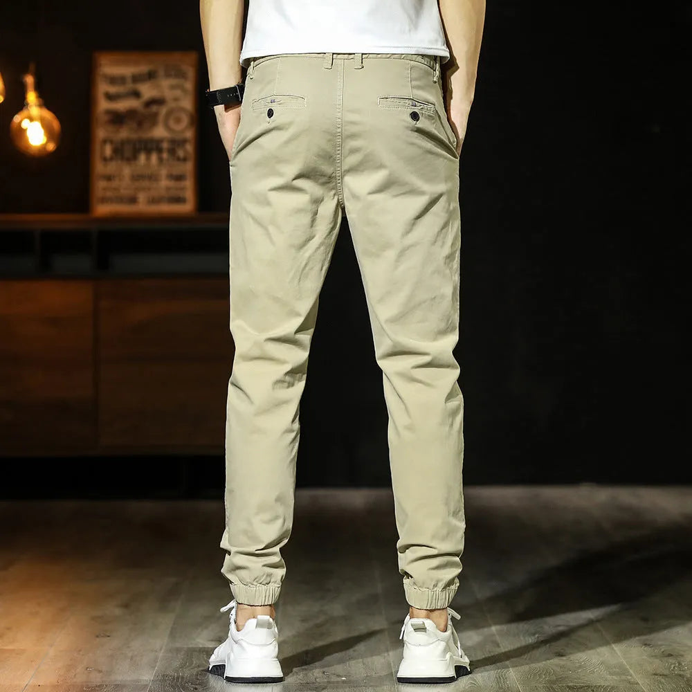 Men's cotton tapered casual trousers with ankle-tied hem, mid waist and zipper fly in khaki, black, coffee army or medium grey.