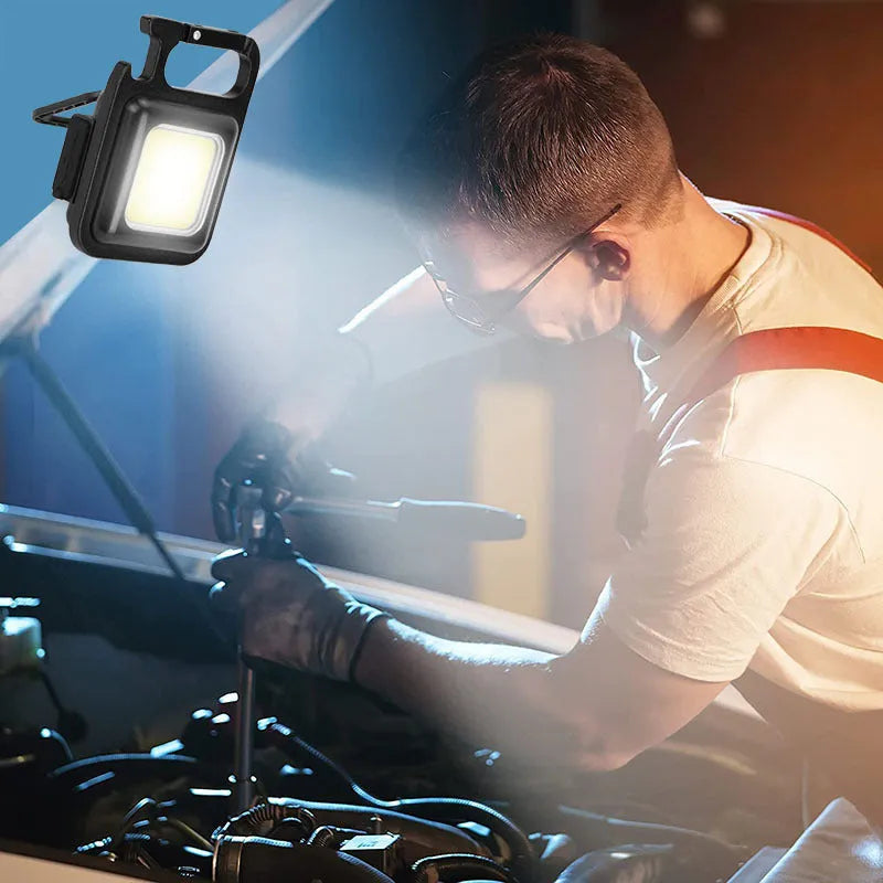 Black aluminium alloy keychain light with magnetic base and foldable handle, measuring 6 cm by 4.2 cm