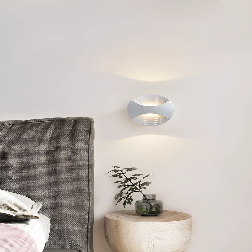 Modern minimalist aluminium wall lamp in black finish with LED light, mounted on a white wall.