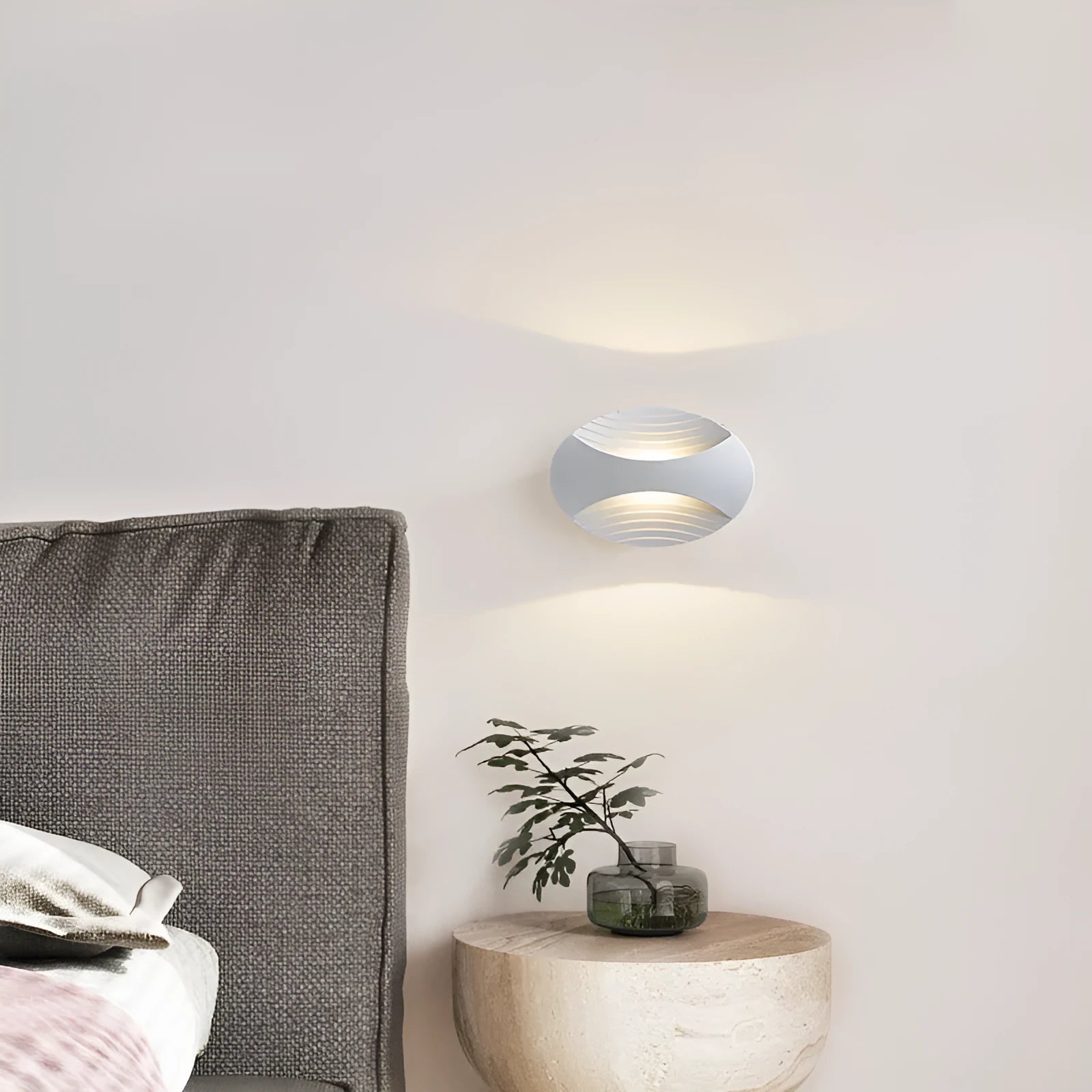 Modern minimalist aluminium wall lamp in black finish with LED light, mounted on a white wall.