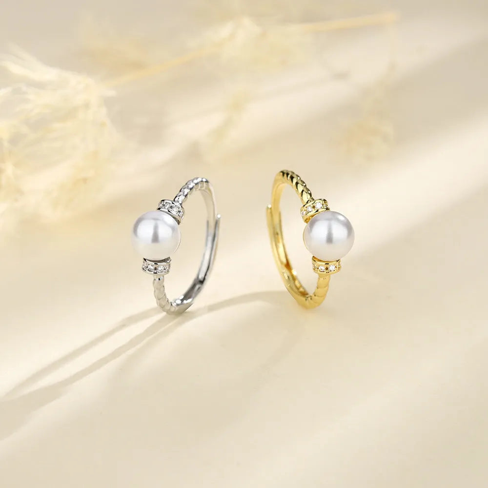 Adjustable copper ring with geometric pearl inlay in antique twist pattern, showing gold and silver finish options
