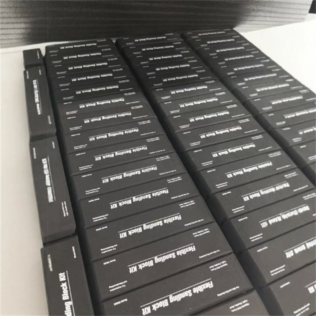 Seven black EVA frosted blocks with metal construction arranged on a work surface