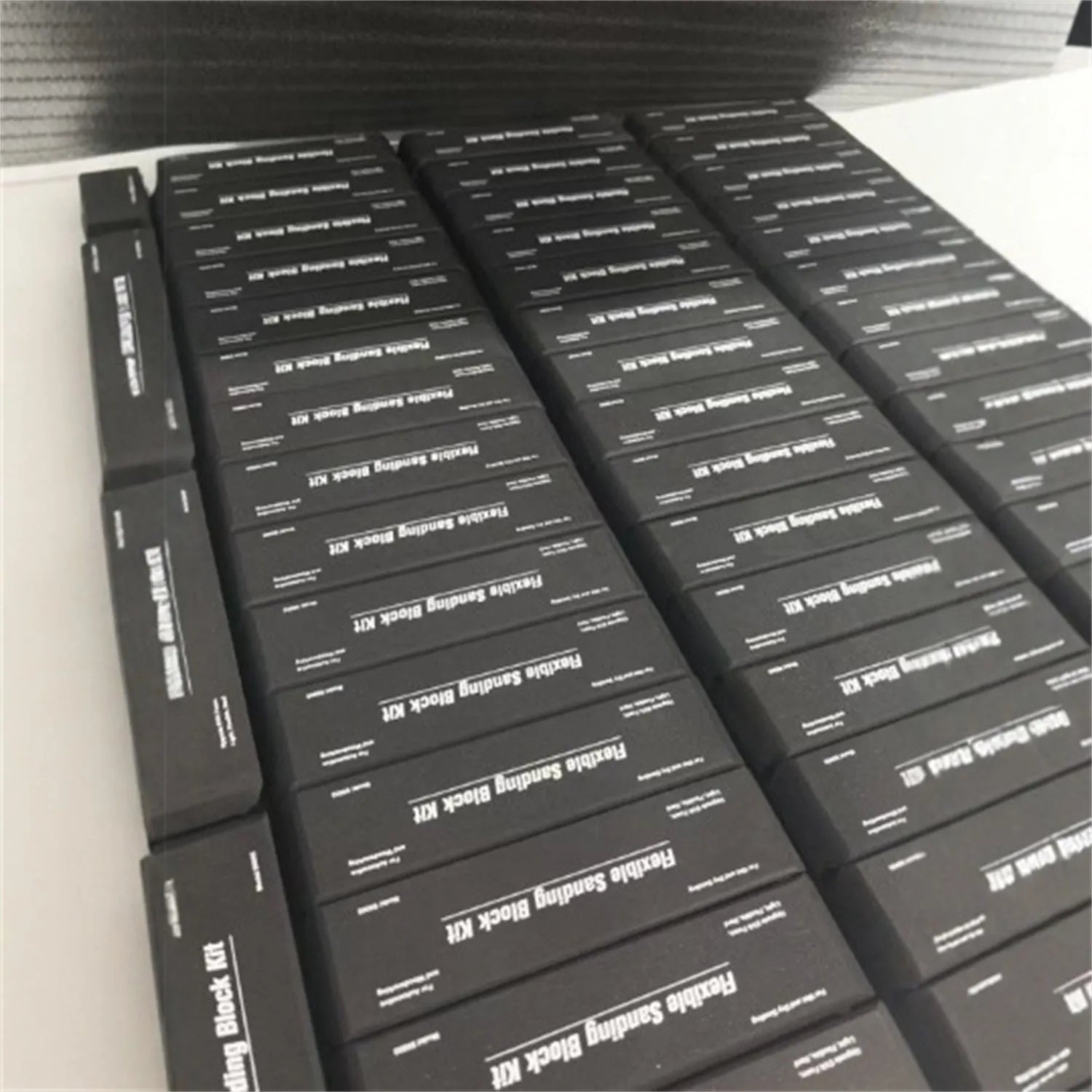 Seven black EVA frosted blocks with metal construction arranged on a work surface