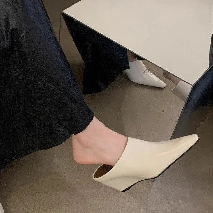 Women's black Wind Wedge closed toe half slippers with PU upper on a plain background.