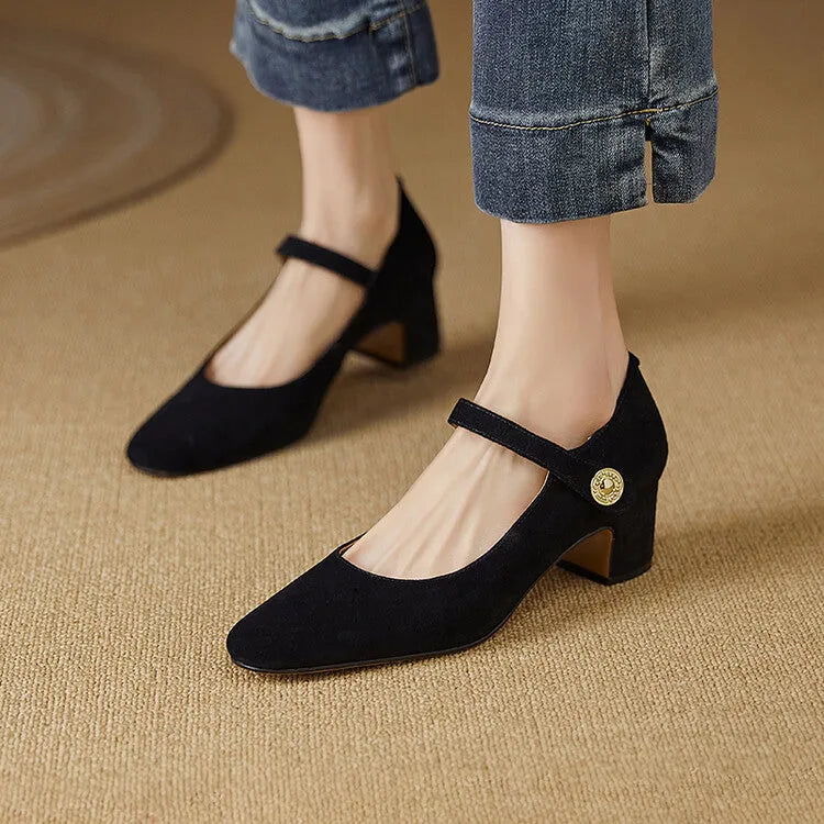 Black suede women's Mary Jane shoes with a chunky heel and square toe on a plain background.