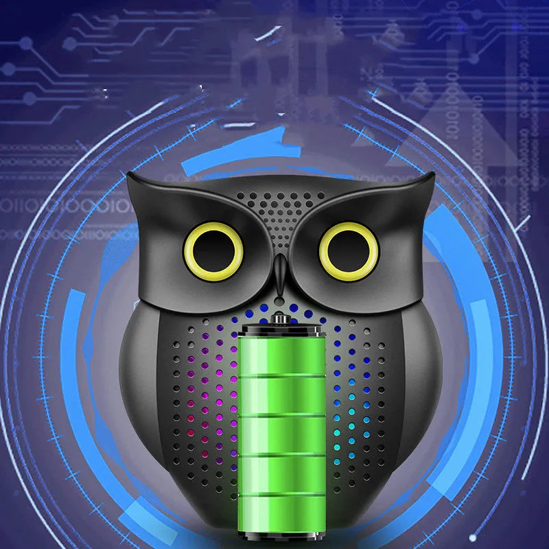 Black plastic owl-shaped portable Bluetooth speaker on a table.