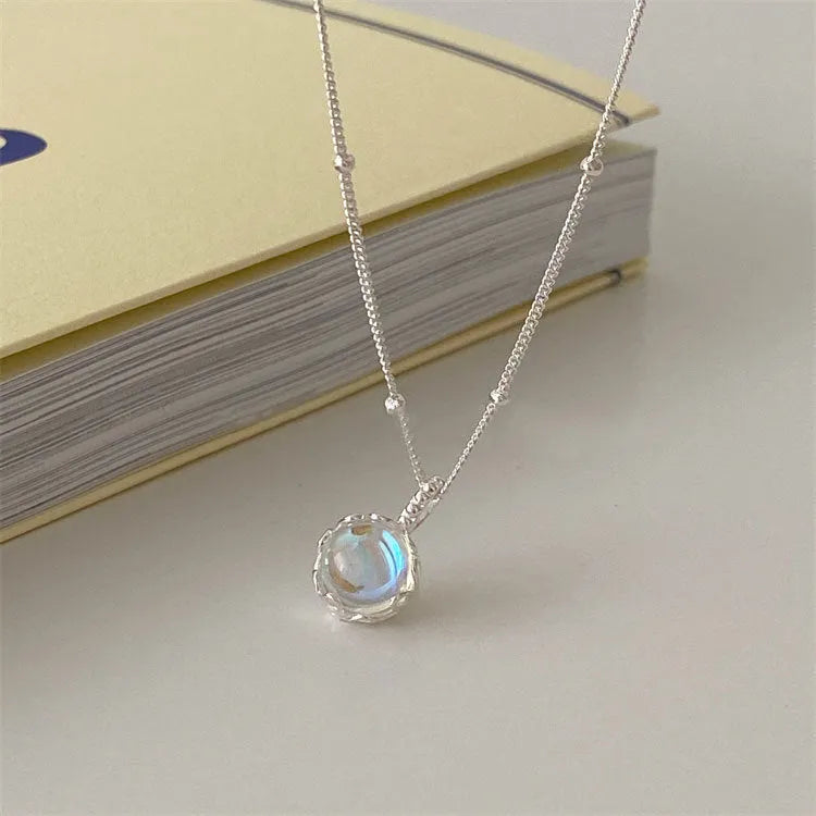 Women's geometric silver necklace with adjustable chain on dark background showing polished finish