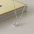 Women's geometric silver necklace with adjustable chain on dark background showing polished finish