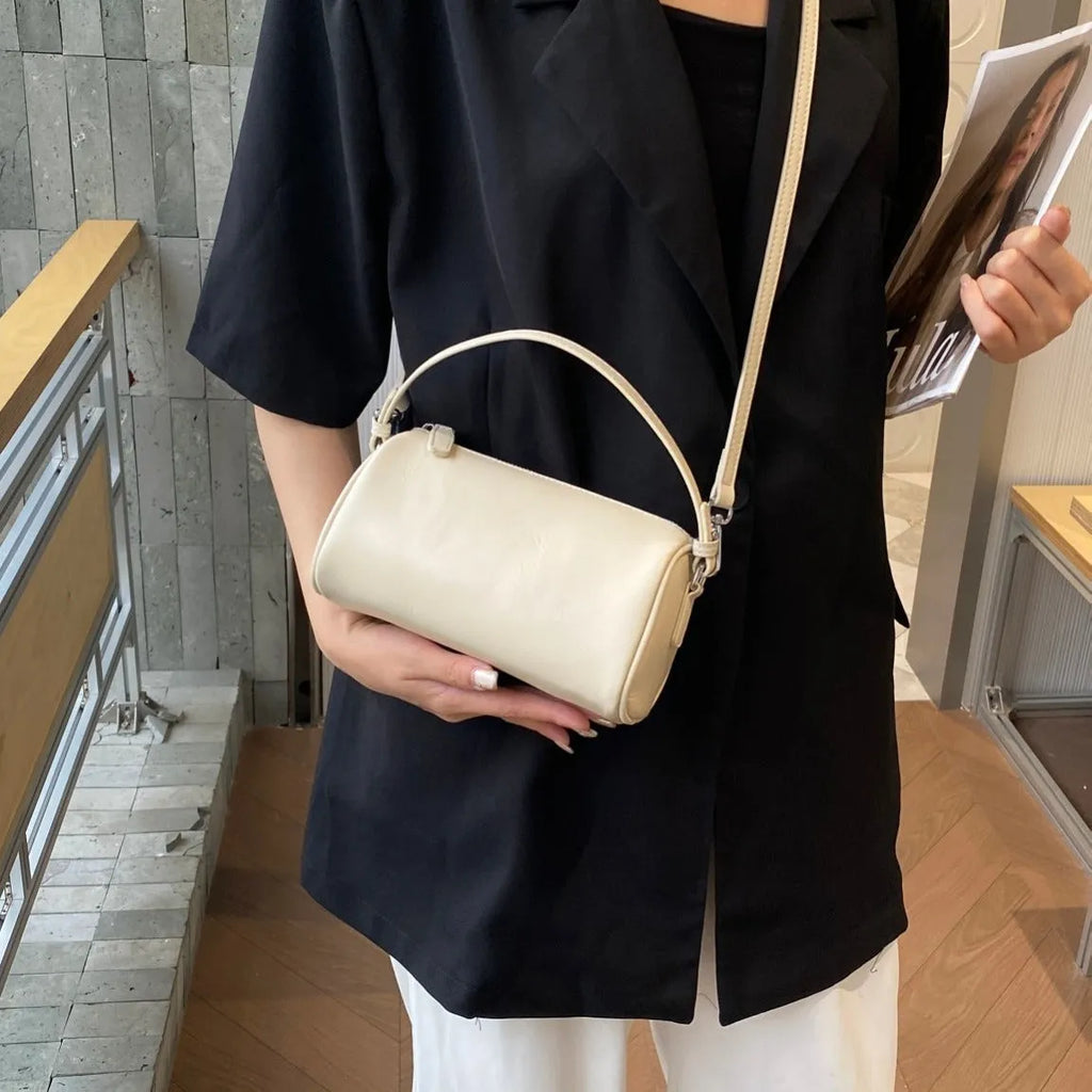 Cylindrical leather crossbody bag for mobile phones in six colours, showing visible sewing thread and compact size.