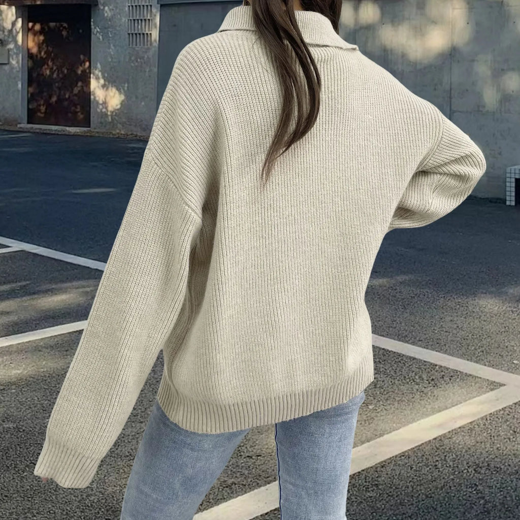 Woman wearing a light khaki alpaca wool pullover sweater with loose lapels, a turtleneck, and an oblique zipper.