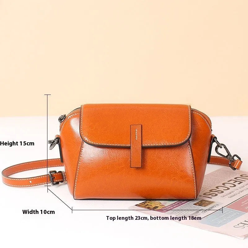 Women's brown oil wax cowhide shell messenger bag with cross-body strap and exterior sandwich pocket