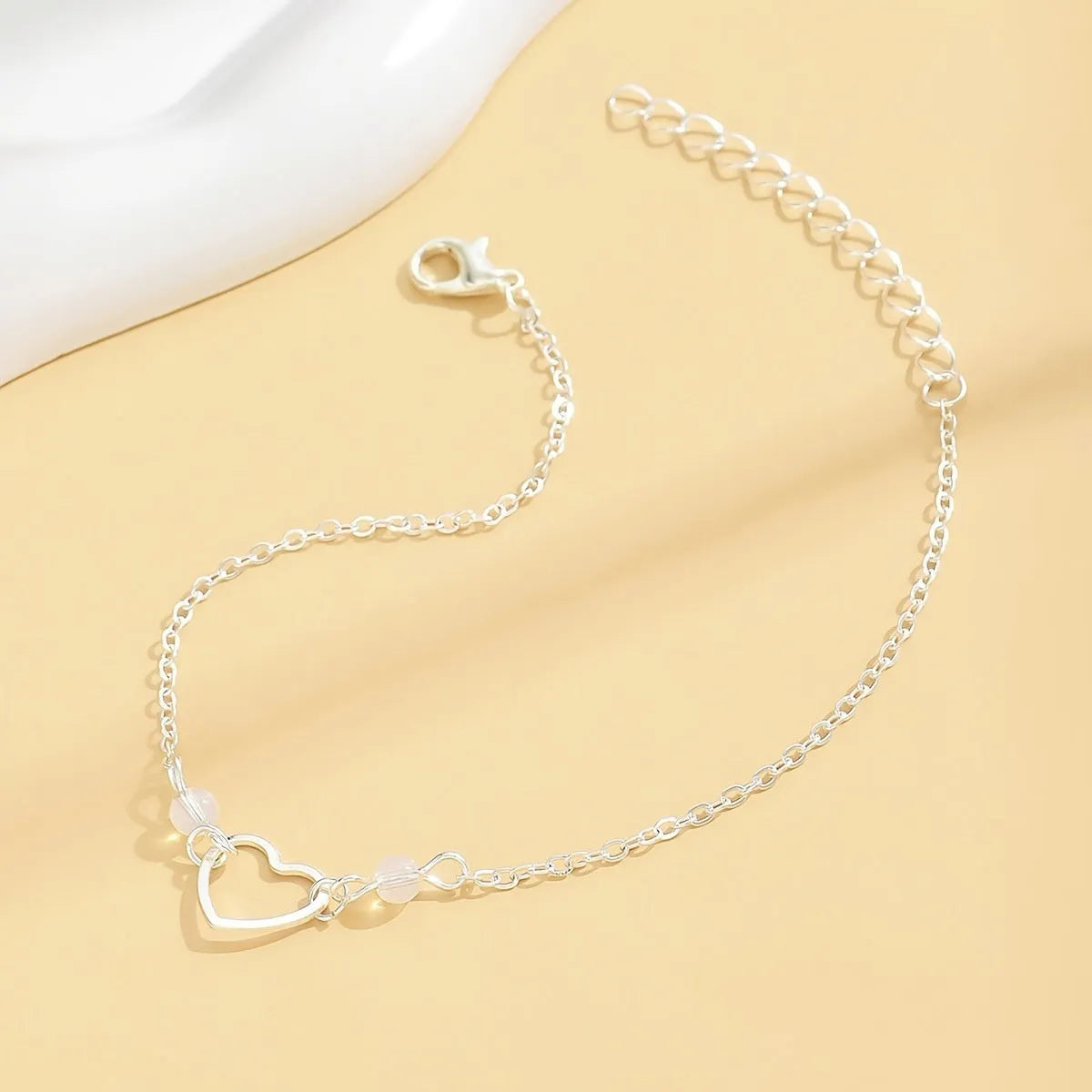 Adjustable heart-shaped pendant anklet in gold or silver finish with geometric design