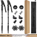 A pair of adjustable silver aluminium trekking poles with various foot attachments on a hiking trail.
