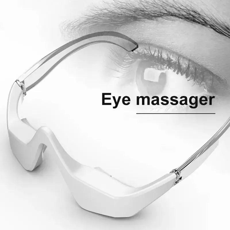 Pink and white USB rechargeable micro-current eye massager with glasses-style frame on a grey background.