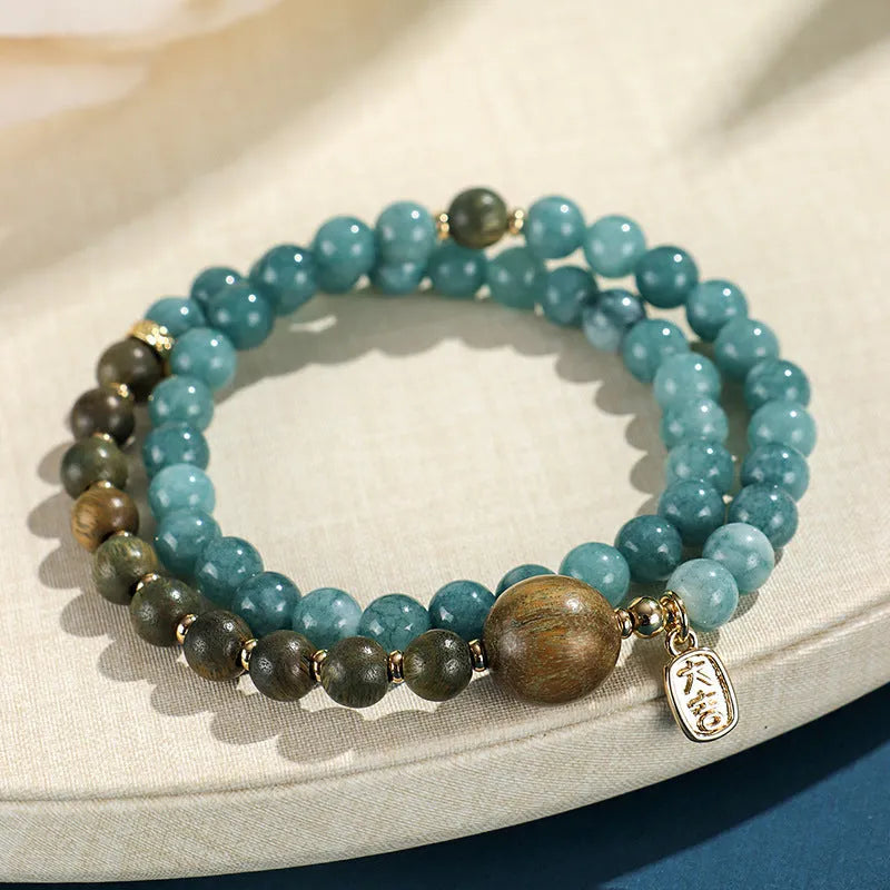 Blue natural stone beaded bracelet with golden sandalwood, guajacwood, or rosewood beads featuring fu and xi characters
