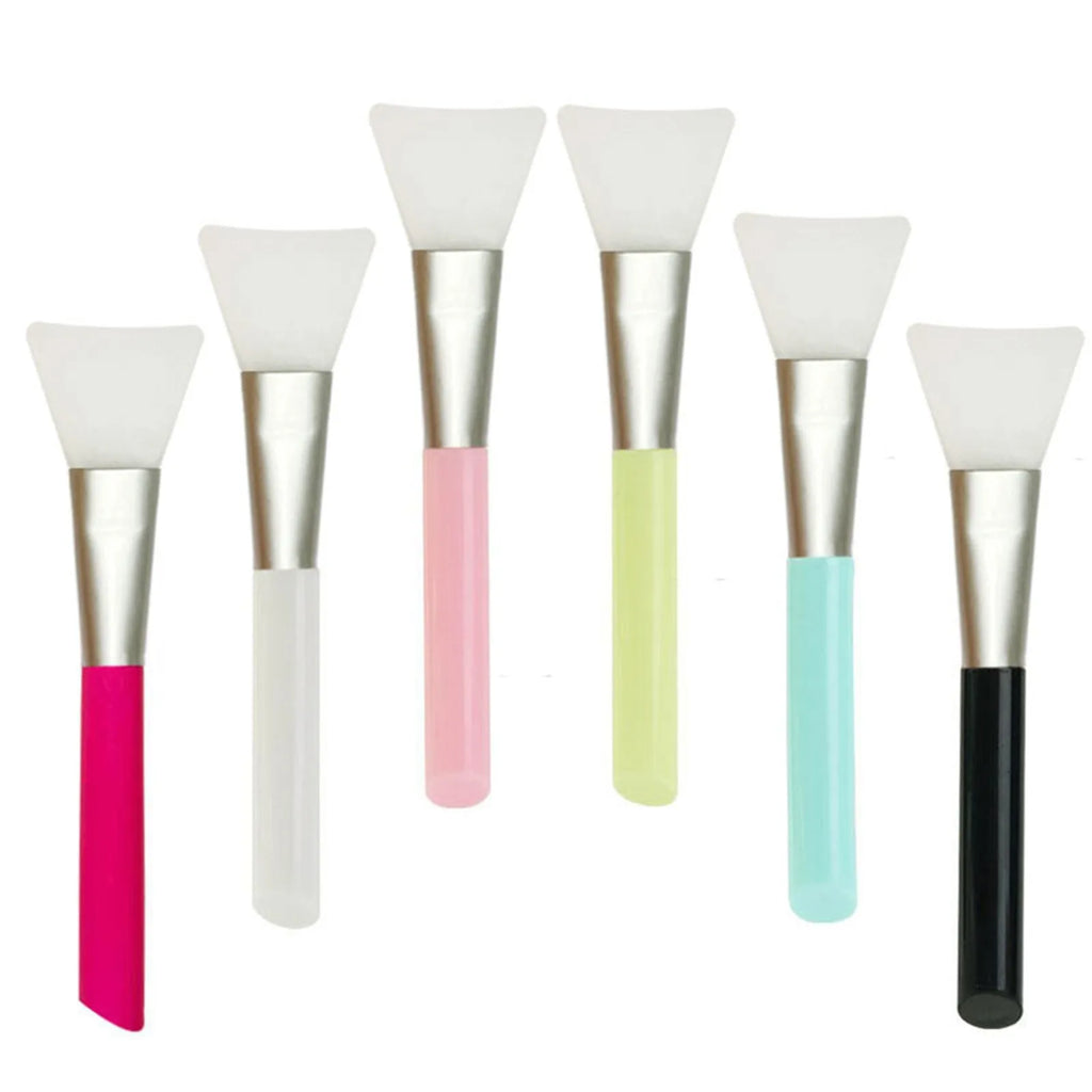 Reusable silicone spatula applicator for face and body masks in various colours on a plain background.