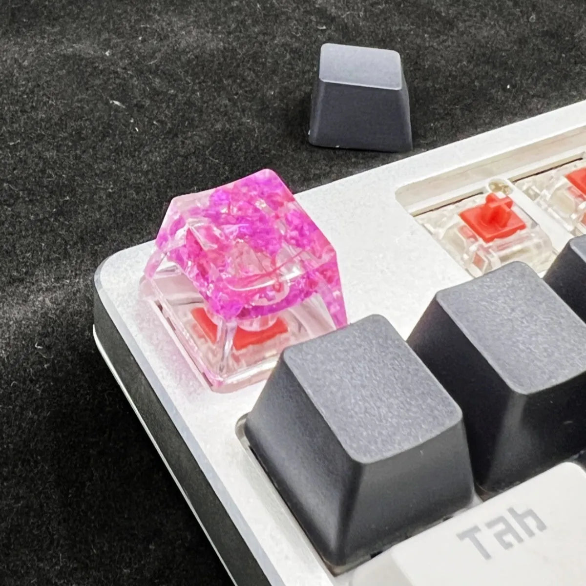 Translucent resin starry sky keycap with glitter particles measuring 1.8cm by 1.2cm