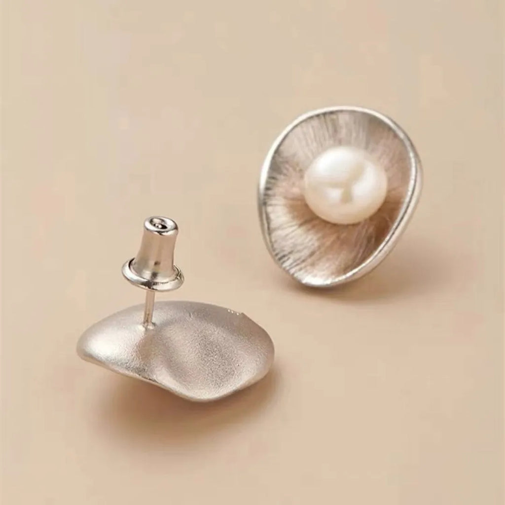 Pearl sterling silver needle earrings with geometric design and 8mm freshwater pearl centrepiece on gold background
