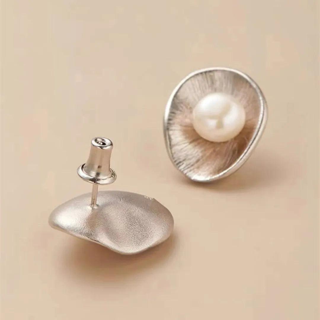Pearl sterling silver needle earrings with geometric design and 8mm freshwater pearl centrepiece on gold background
