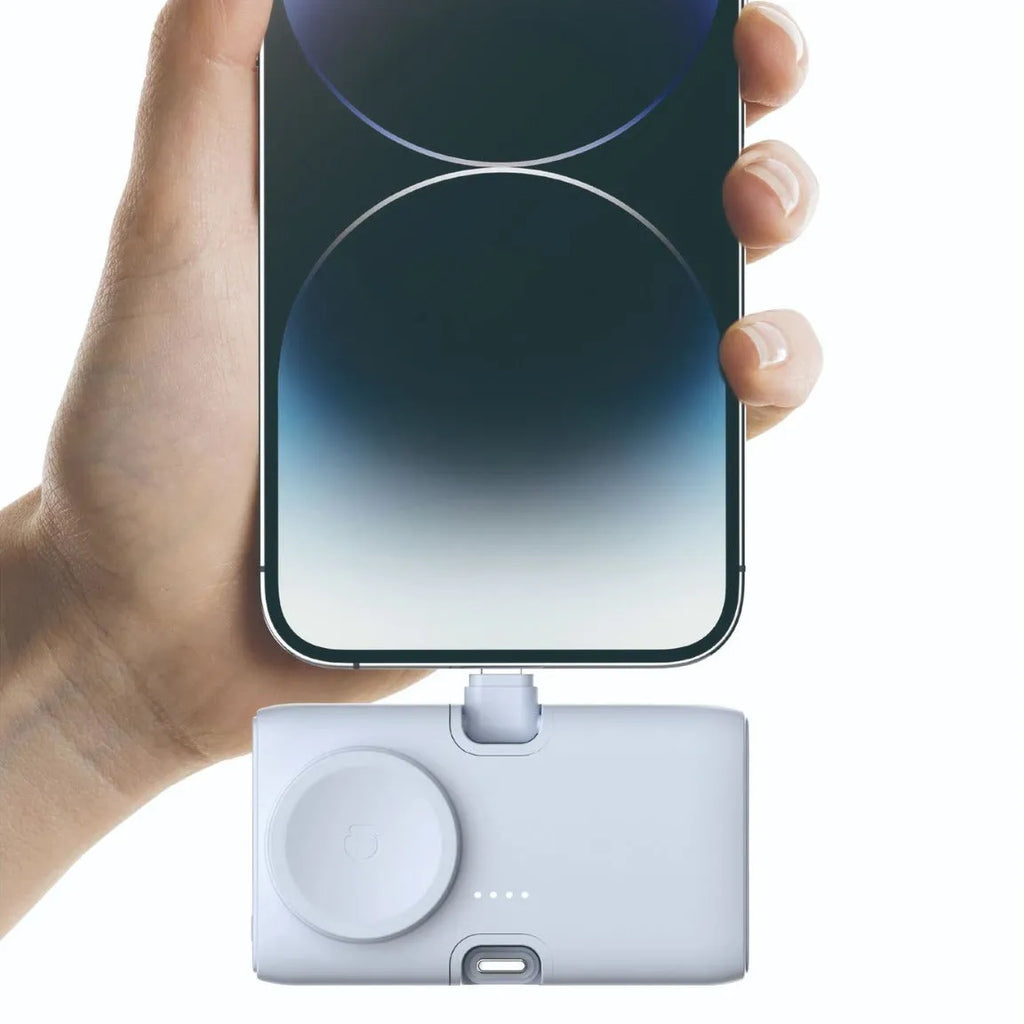 Compact white plastic wireless power bank with 5000mAh capacity, shown next to a smartphone.