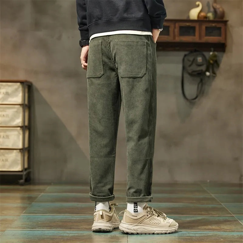 Men's tapered corduroy trousers in army green showing straight-leg street fashion style