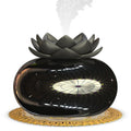 Black round Lotus aromatherapy humidifier with USB cable and mechanical dial on a table