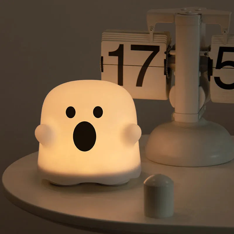 White silicone touch sensor LED night light on a bedside table.