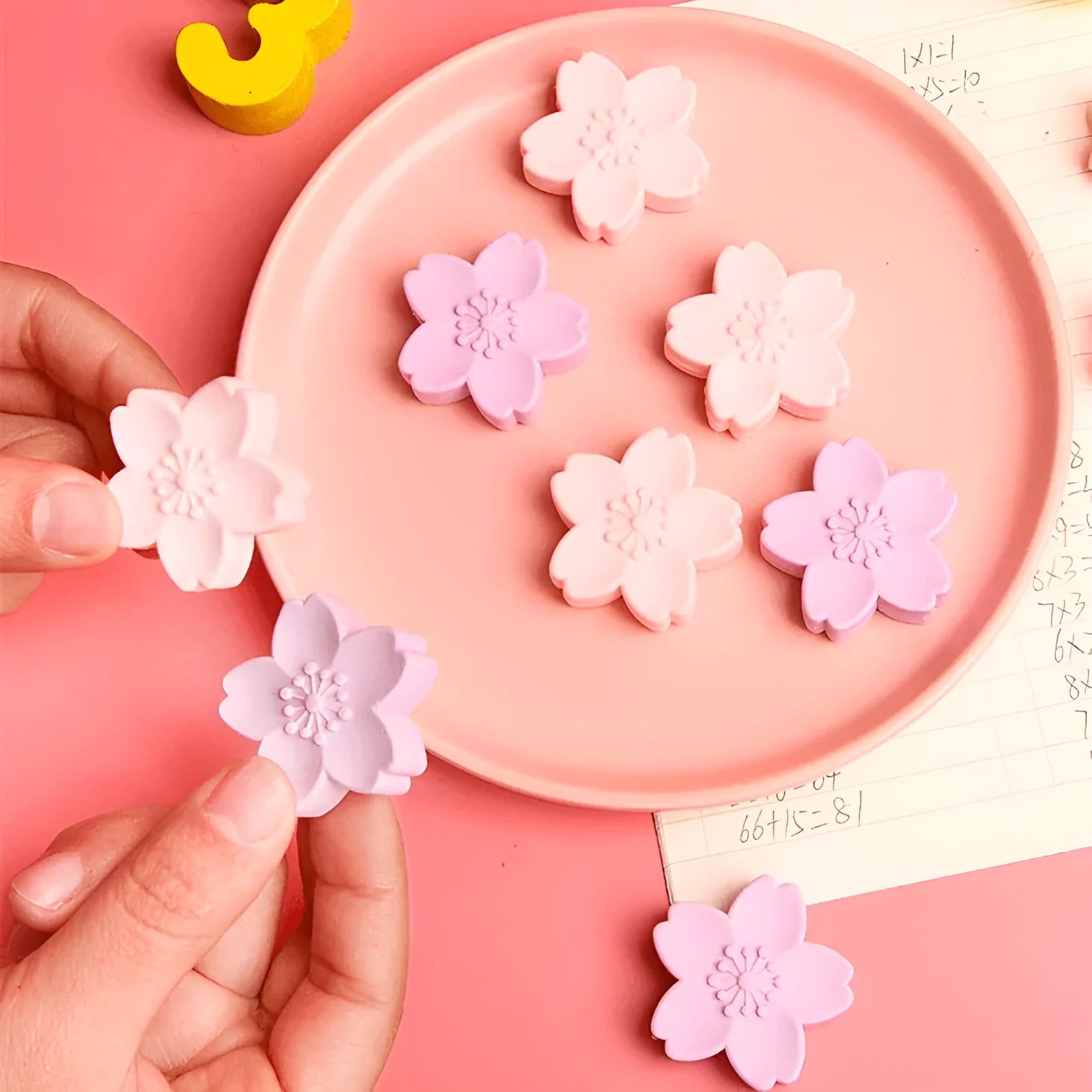 Pack of cherry blossom design student erasers on a desk, shown to leave no marks or debris.