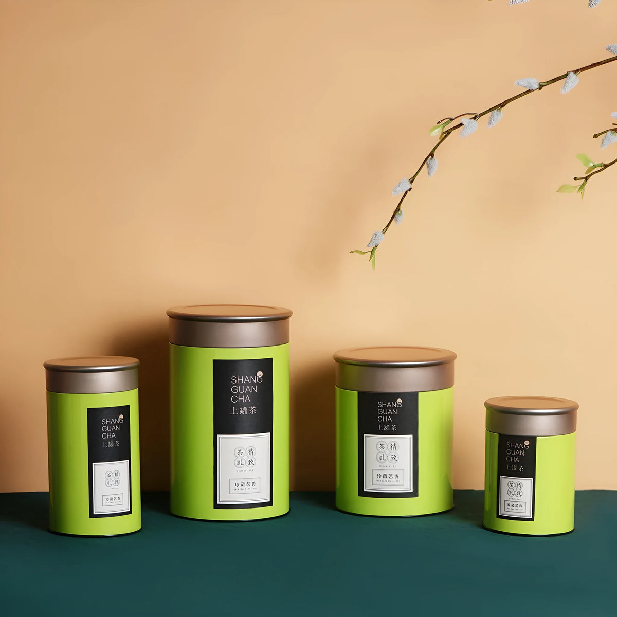 Green metal tin can tea storage box with sealed lid, shown next to loose-leaf tea.