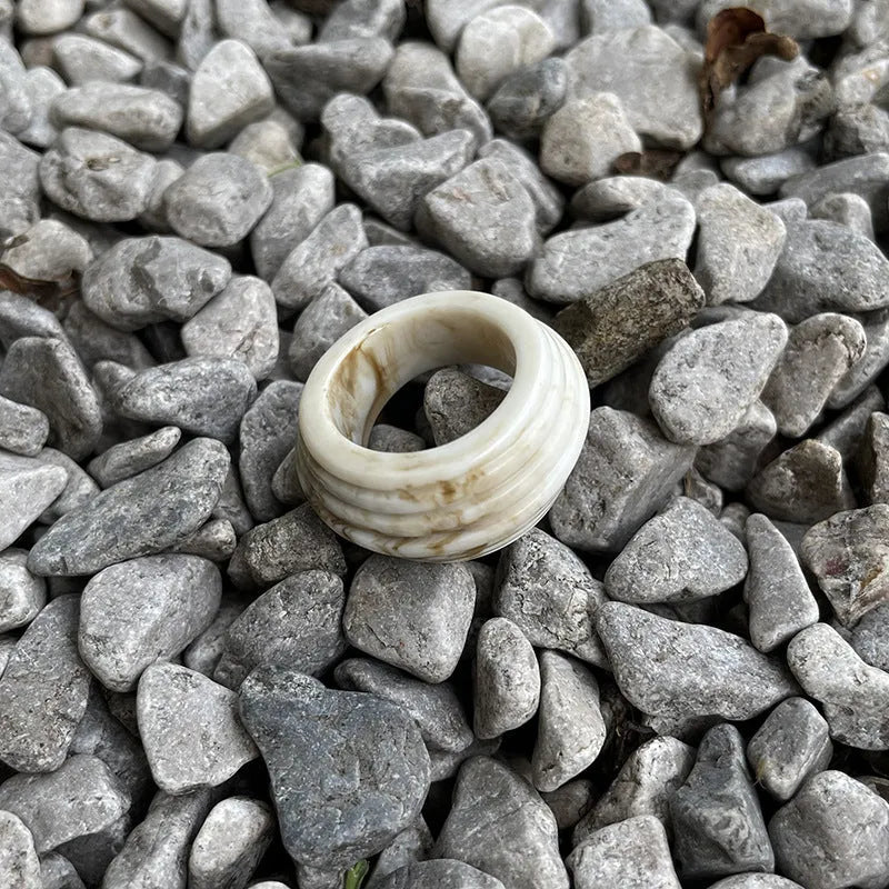Geometric irregular resin wide ring in brown and white colour options on a hand.