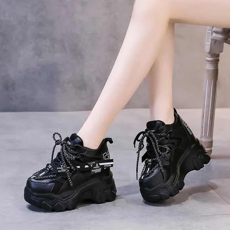 Women's white low-top platform sports shoes with cross strap and rubber sole on a light background