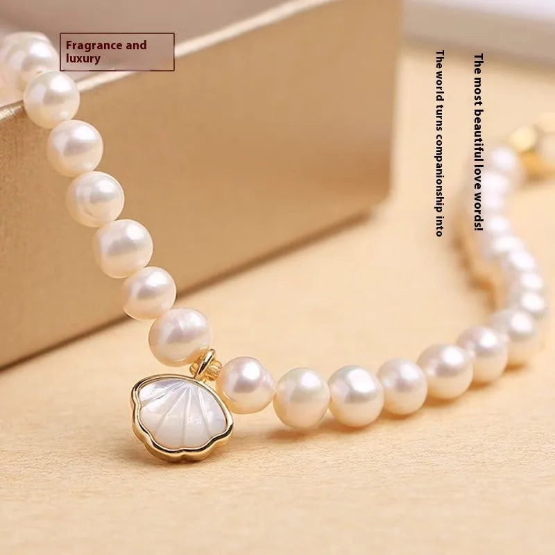 Freshwater pearl bracelet with fan-shaped shell design showing elastic and chain fastening options