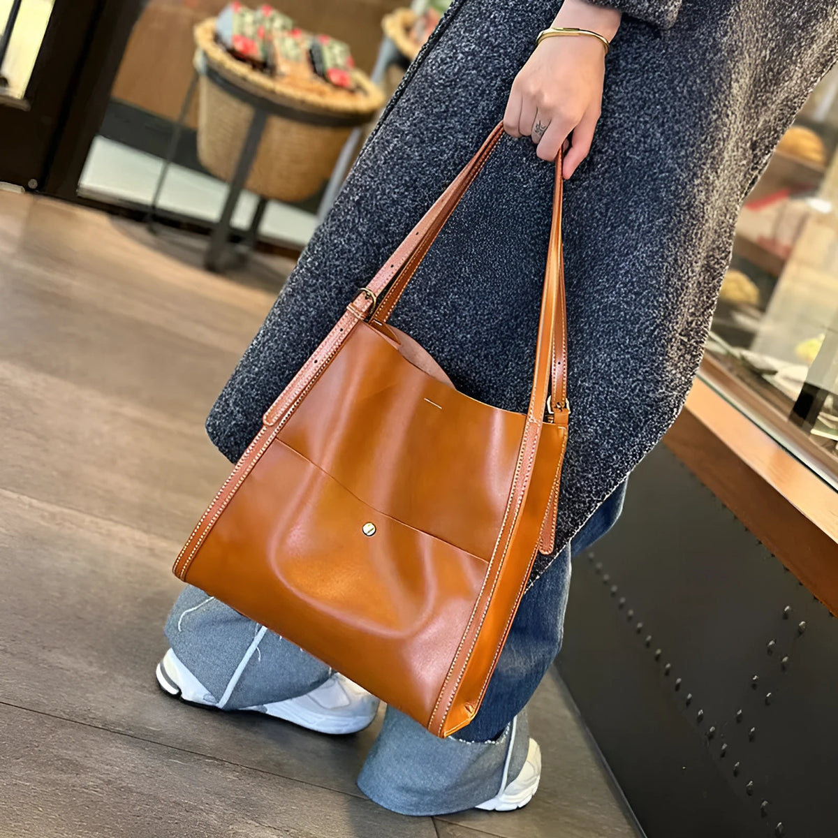 Large square leather tote bag in sunset yellow with open top showing internal organiser pockets.