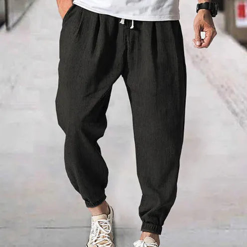 Man wearing loose light-coloured cotton trousers with a banded ankle cuff