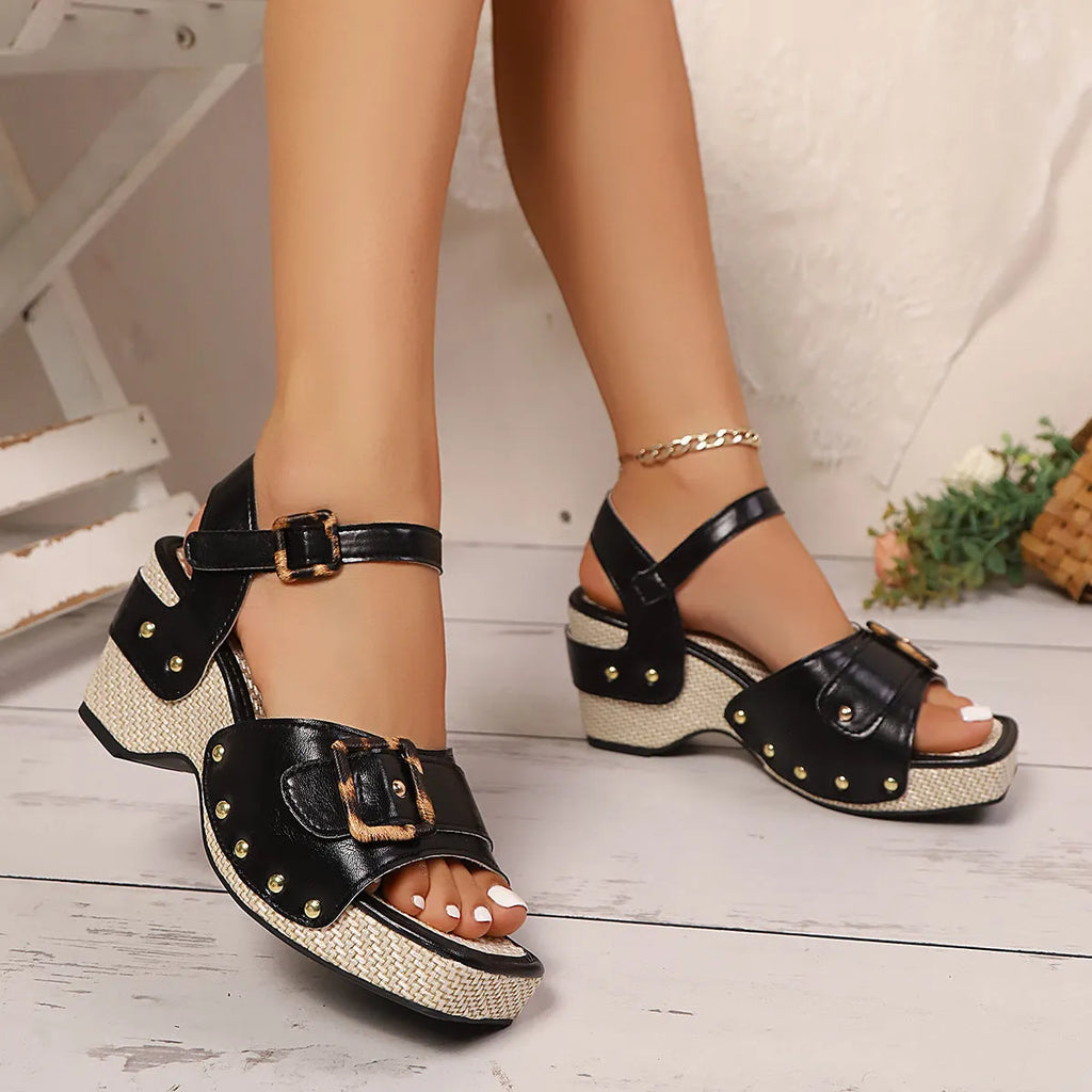 White women's sandals with a metal buckle strap and chunky block heel on a square toe.