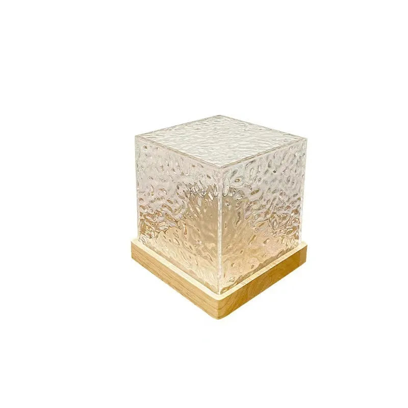 Crystal table lamp projecting blue water ripple light pattern on wall
