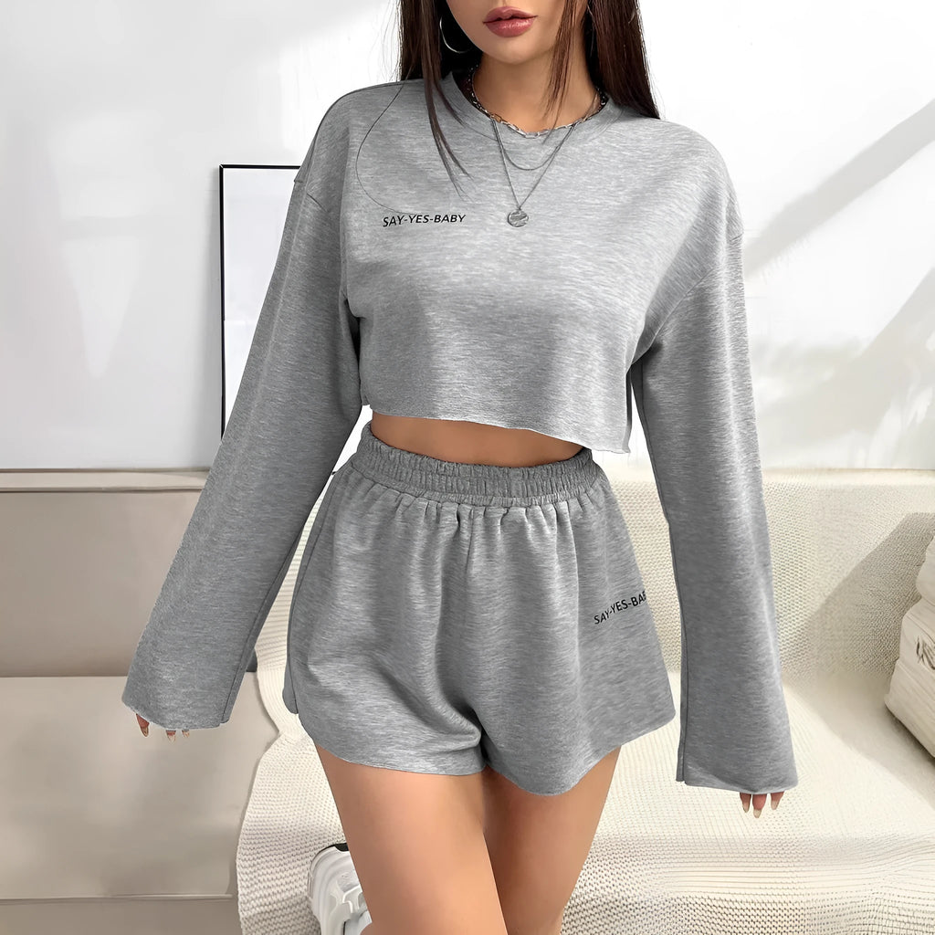 Grey women's long-sleeved polyester top and shorts casual suit set laid flat.