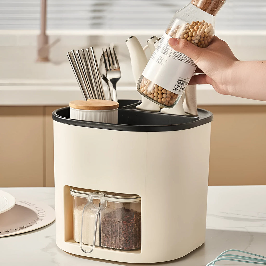 White rotating kitchen storage bucket with utensils next to a four-compartment spice box on a countertop.
