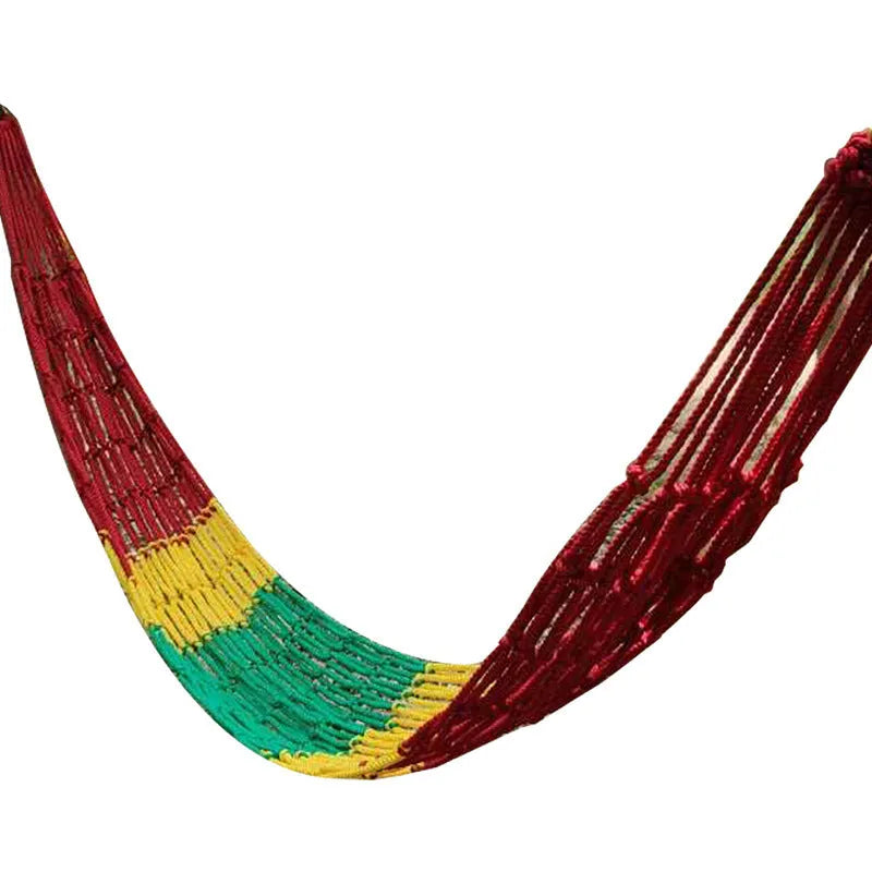 Green nylon rope mesh hammock hung between two trees with tying ropes.